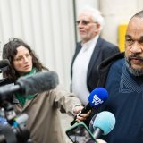 L'humoriste Dieudonné face aux sollicitations des médias avant d'entrer au Palais de justice de Genève.
